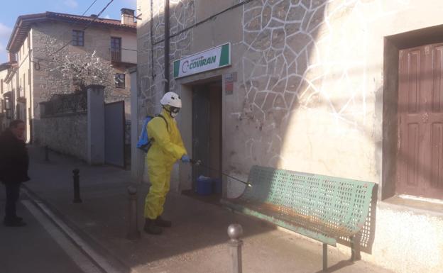 Un operario desinfecta un banco.