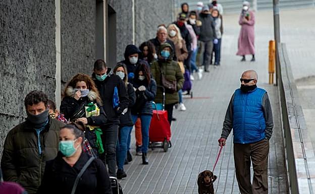 Varios clientes guardan cola para entrar en un supermercado de Badalona. 