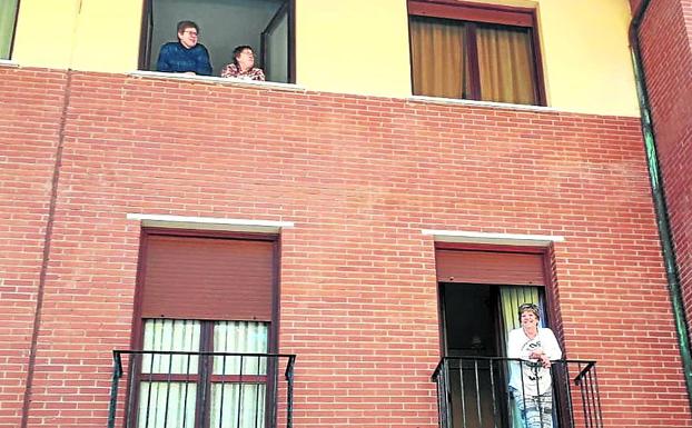 Residentes en Gizaburuaga pasan el rato conversando de balcón a balcón. 