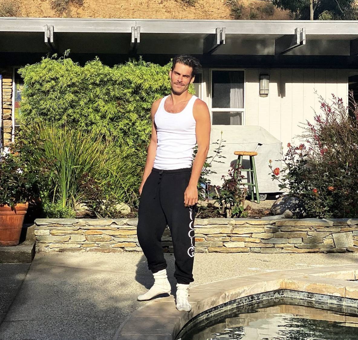 El modelo y actor bilbaíno Jon Kortajarena, de 34 años, también quiso mostrar cómo se puede vestir con mucho estilo en este confinamiento en casa. En el primer look eligió un pantalón de chándal negro de la firma de lujo Gucci y lo combinó con una camiseta blanca de tirantes.