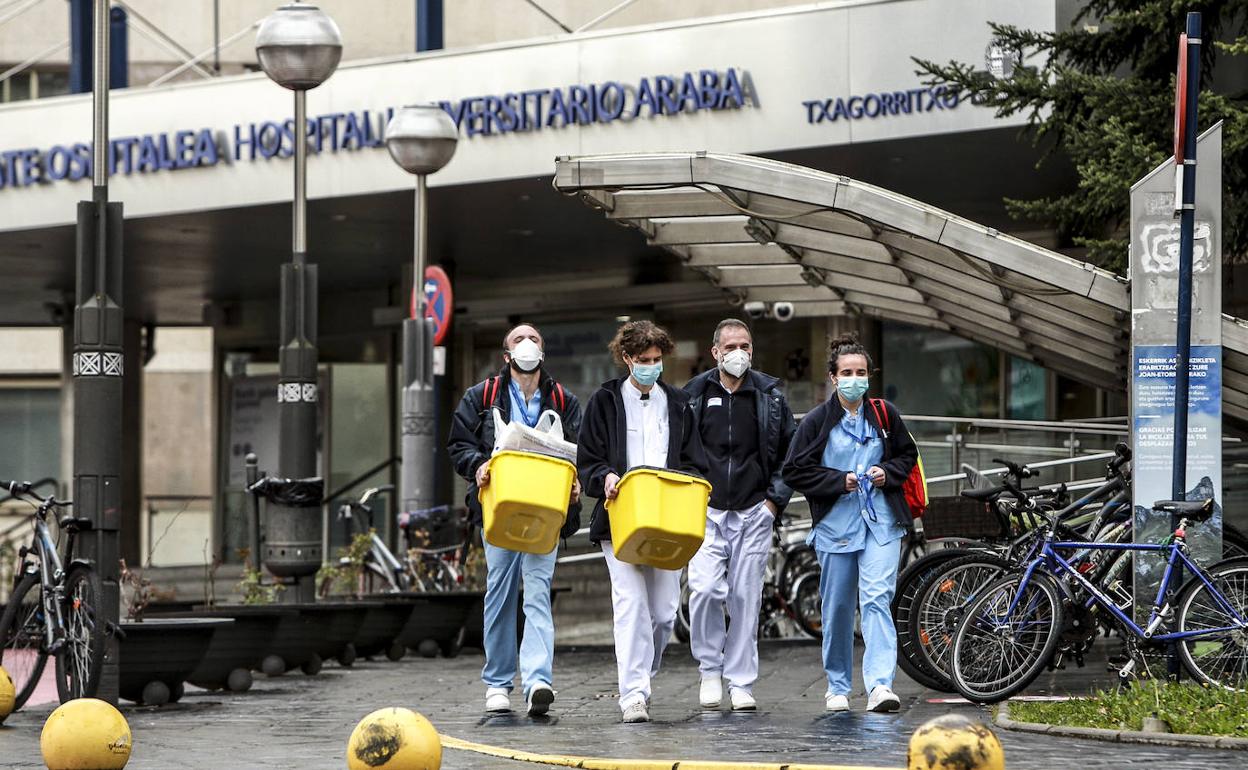 Personas con material sanitario en la salida del hospital de Txagorritxu. 