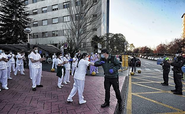 Saludo con el codo entre una sanitaria y un guardia civil. 