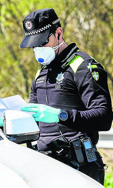 Un policía, con mascarilla. 