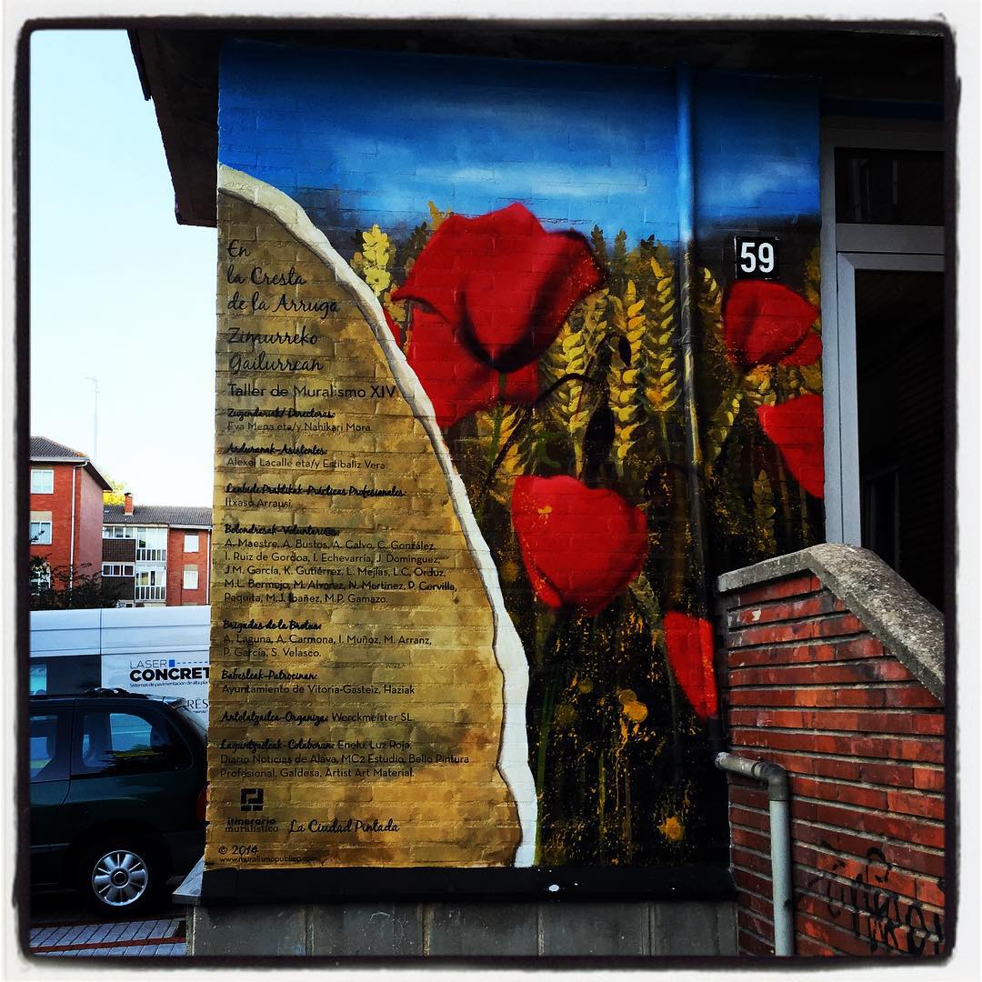 El itinerario muralístico de Vitoria tiene varias paradas en Zaramaga. Allí hay una obra con la que sus autores quisieron rendir homenaje a las personas mayores de este barrio de tradición obrera que, poco a poco, ha ido envejeciendo. Un vecindario poblado de inmigrantes llegados desde otras provincias y, más recientemente, procedentes de otros países. El trabajo artístico, que ocupa una superficie de unos 120 metros cuadrados, se pintó entre los años 2014 y 2015. Está situado en la calle Mendoza, 59; aunque la visión óptima para apreciarlo en su totalidad se localiza en el punto oeste de la plaza de Llodio. Esas amapolas y espigas, situadas junto a las escaleras de acceso al portal, forman parte del conjunto.