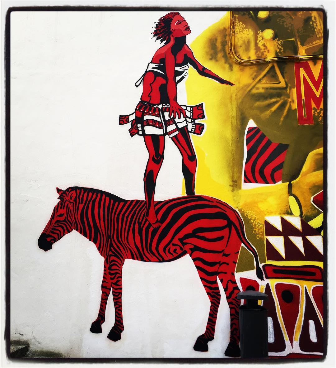 En el barrio de Coronación, muy cerca del centro cívico Aldabe, podemos encontrar un espectacular mural de inspiración africana, fruto de la iniciativa Maldanbera Fest, donde llama la atención esta curiosa cebra rojinegra. Puede verse en la zona peatonal de la calle Eulogio Serdán.