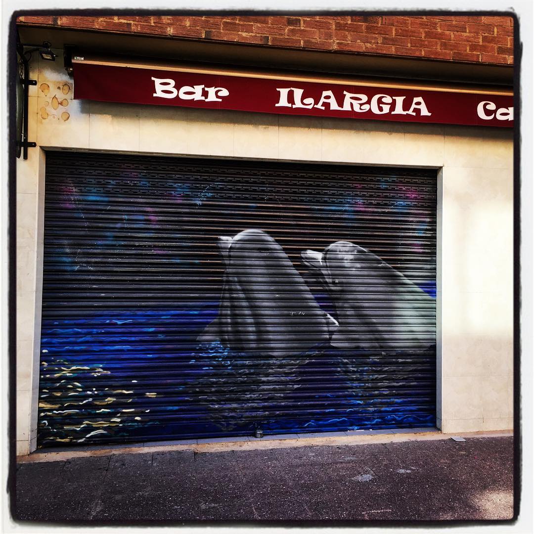 Esta pareja de delfines está pintada sobre la persiana de un establecimiento hostelero ubicado en el barrio de San Martin.