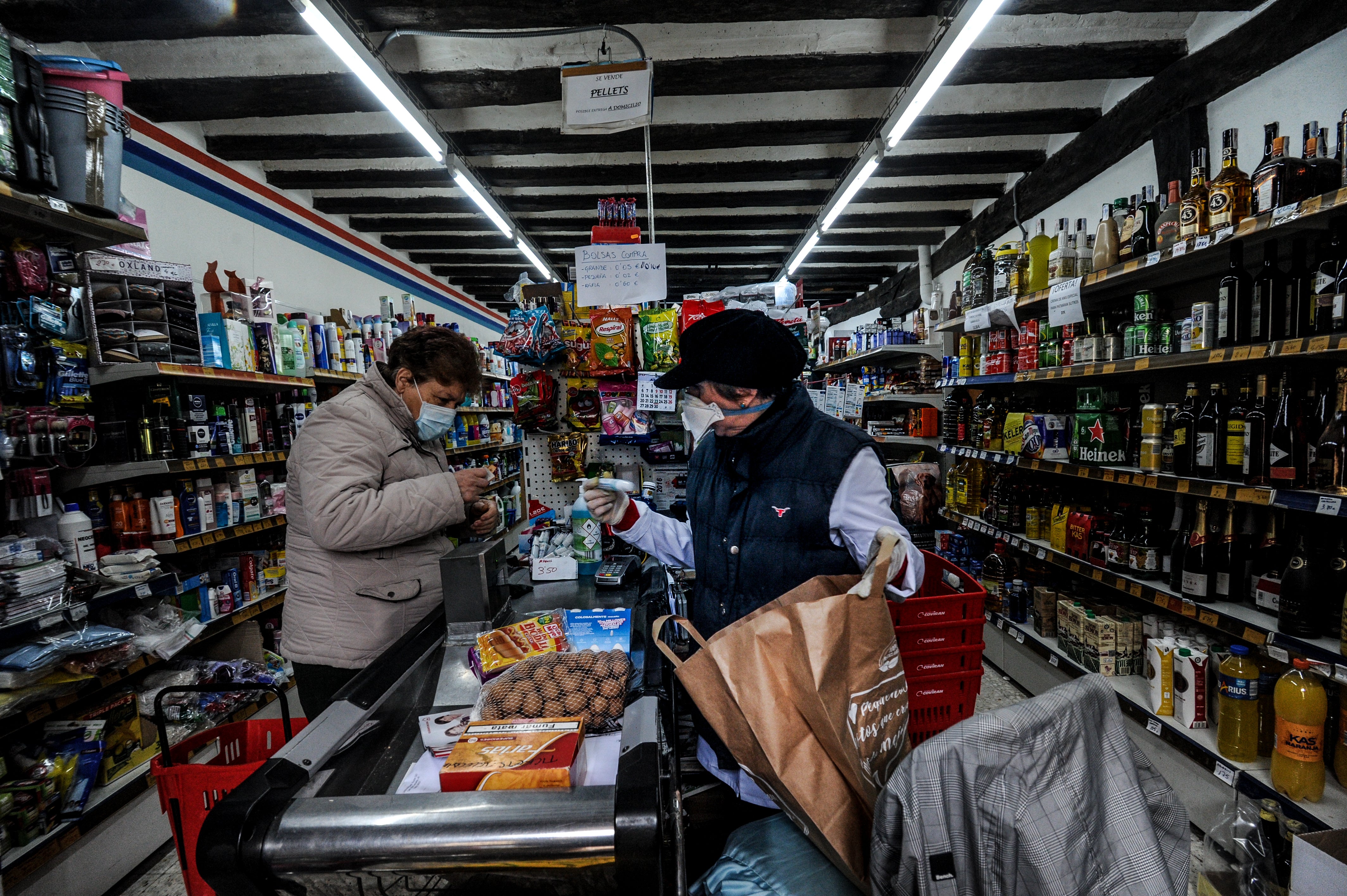 Begoña Martínez, a la derecha, solo permite la entrada de uno en uno en el supermecado de Espejo. Francisca Vilche, a la izquierda, aprovecha el viaje para llenar la despensa de su residencia en San Zadornil.