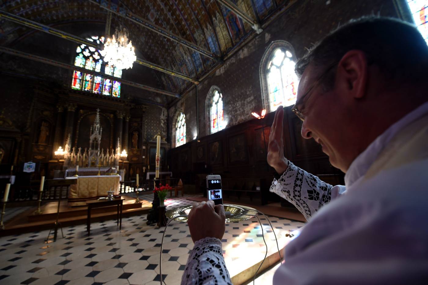 El sacerdote francés Olivier Monnier hace una videollamada con sus feligreses después de celebrar una misa de Pascua, en la iglesia de Saint-Jacques en Illiers-Combray, oeste de Francia, el día 27 de un estricto encierro en Francia para frenar La propagación de COVID -19 causada por el nuevo coronavirus.