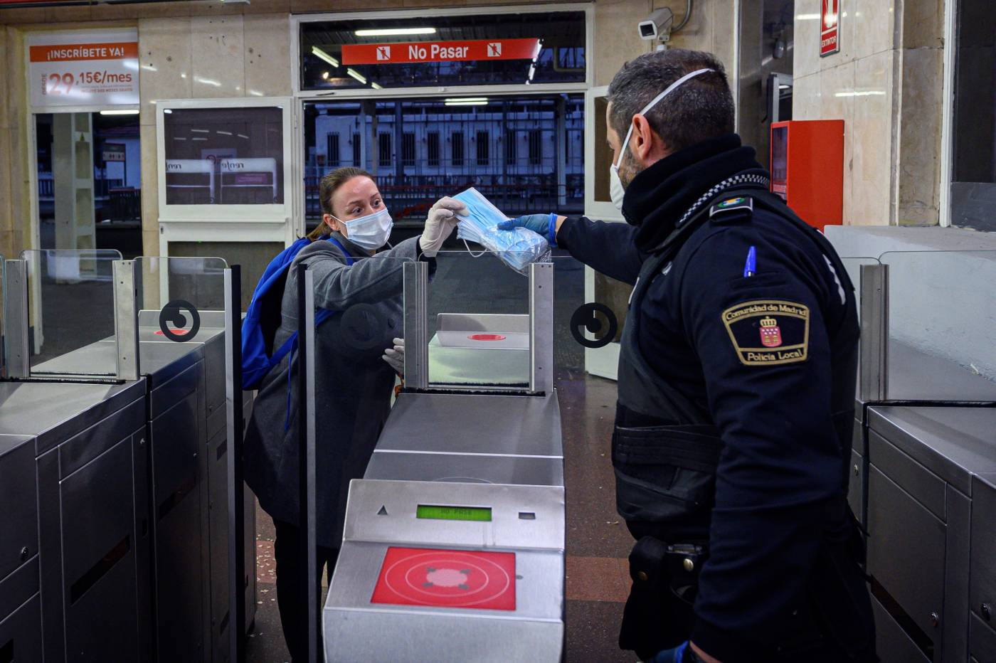 Policías entregan mascarillas en la estación de cercanías de Alcalá de Henares, Madrid.