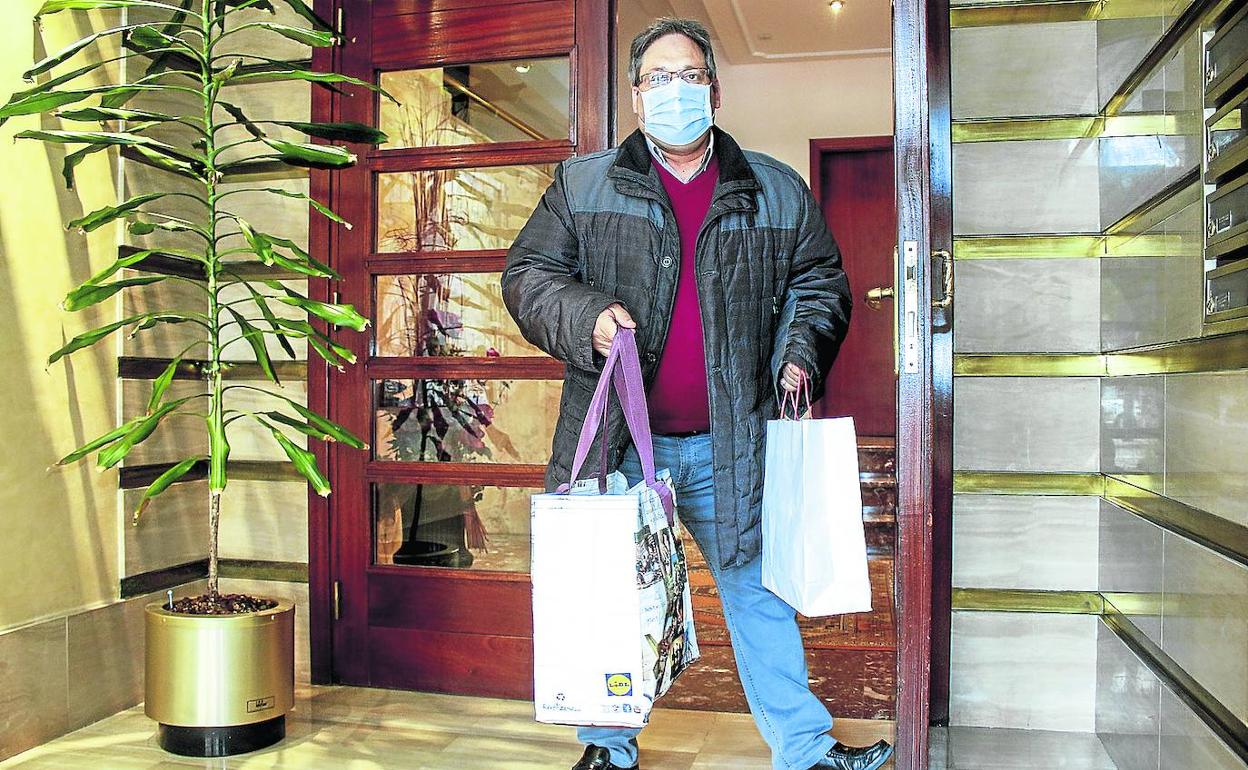 Miguel Ángel Fernández sujeta la puerta del portal de su madre, de 86 años, un día que acudió a ayudarla. 