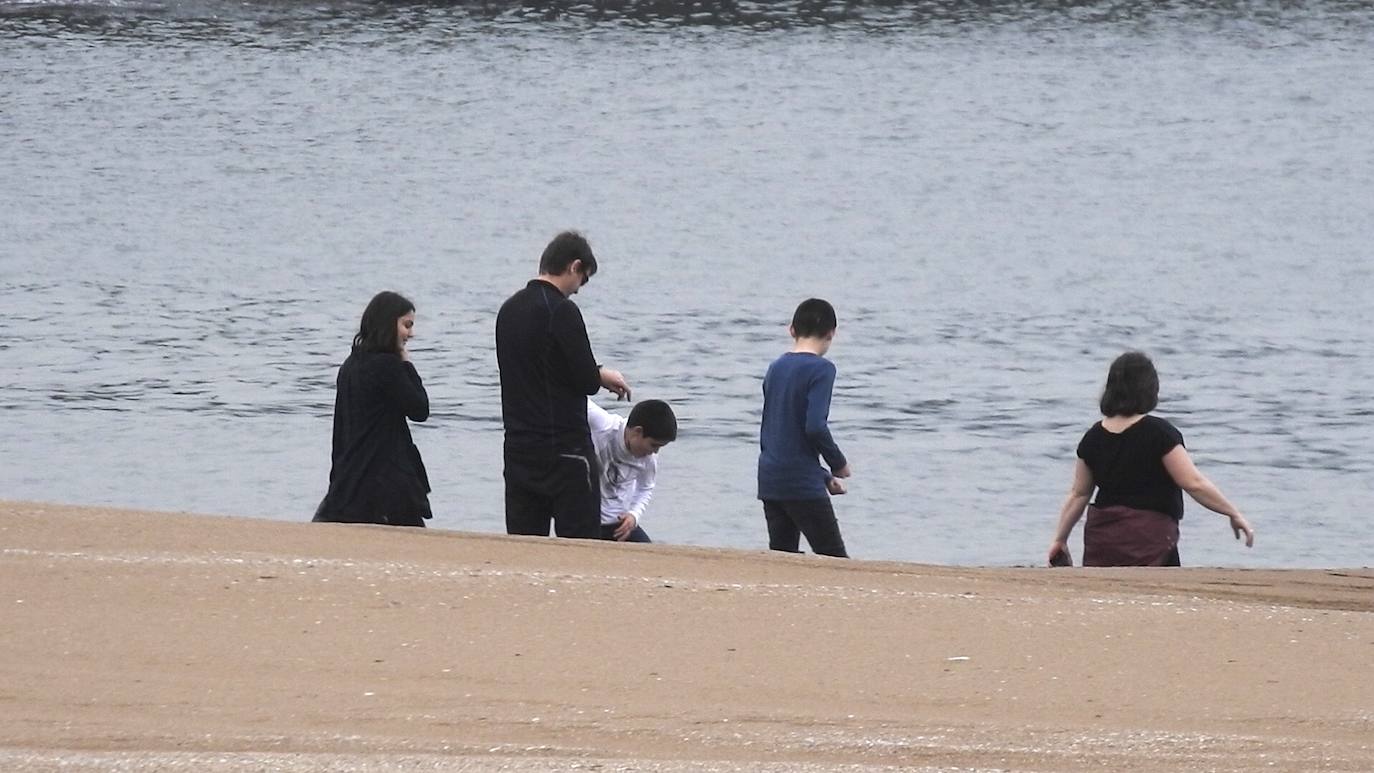 Un grupo de cinco personas en la playa de Ereaga.