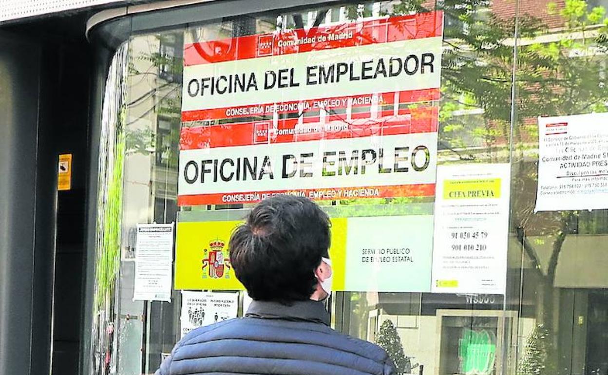 Un hombre revisa los carteles de una oficina de empleo.