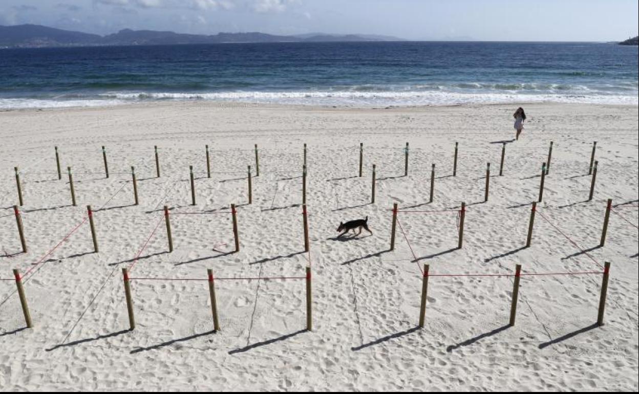 Balizas de prueba que delimitan un cubículo para determinado número de personas en la playa de Sanxenxo.