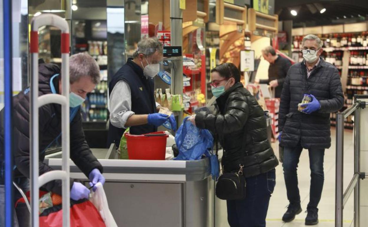 Varias personas hacen la compra con medidas de seguridad