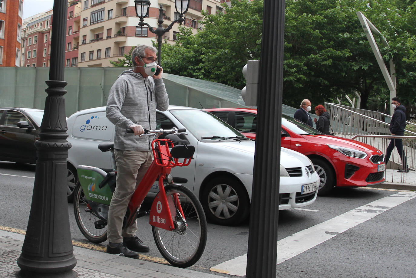 Un hombre con una bicicleta municipal en Bilbao.