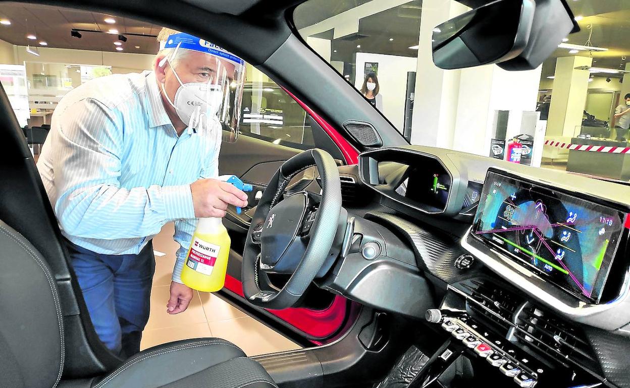 El vendedor Mateo Rodríguez, de 61 años, desinfecta un coche Peugeot en Karealde. «No me esperaba algo como el coronavirus», decía.