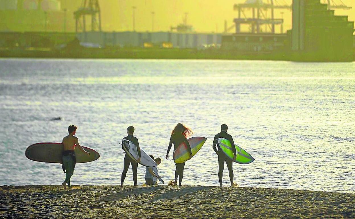 Un grupo de surfistas aprovecha el atardecer en Ereaga.