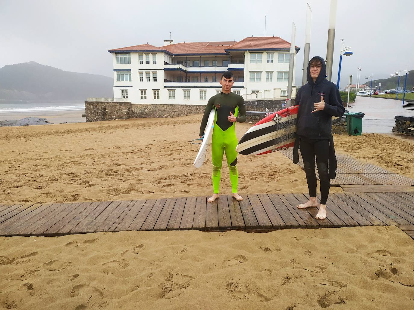 El ansiado reencuentro. Cinco meses después, Álex Ríos y Guillermo Gutiérrez vuelven a reencontrarse con las olas. Aunque el primer contacto lo tuvieron ayer, en Bakio. "Echábamos de menos al mar, el primer baño nos lo dimos ayer. Hoy más", comentan estos dos vecinos de Mungia. "Había ganas. Y ya sabes, al mal tiempo buena cara", bromean. Porque a ellos la lluvia les da igual, más aún con los neoprenos ya enfundados. "Nos vamos a mojar dentro, así que...", Razonan. Por delante les espera "una hora, o quizá dos, de surf", prometen.
