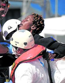 Imagen secundaria 2 - 35 inmigrantes llegados a Puerto del Rosario, en Fuerteventura, a finales del pasado abril reciben asistencia de Cruz Roja. | Un sanitario atiende a un bebé nacido durante la travesía mientras una mujer rescatada por un velero llega a Mogán tras diez días de travesía.