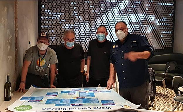 José Andrés, a la derecha, con los hermanos Adrià en Barcelona ante un mapa con las diez ciudades donde ya trabaja World Central Kitchen.