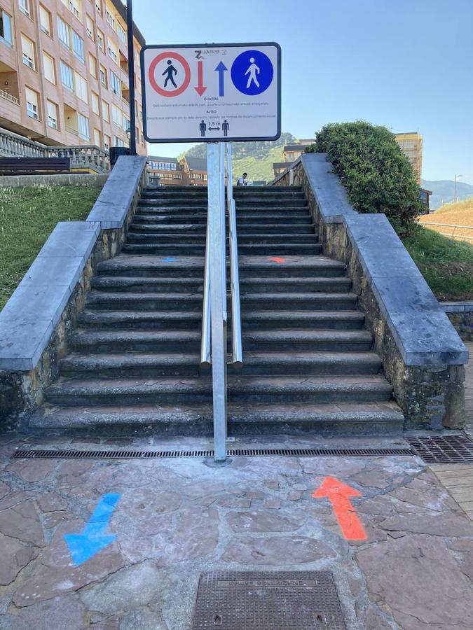 Flechas rojas y azules indican el lugar por el que se debe acceder a la playa de La Arena en Zierbena