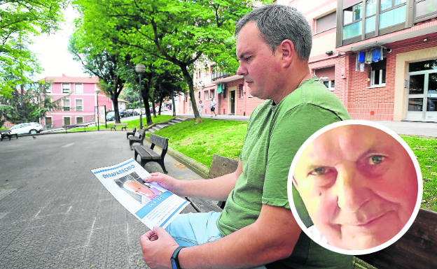 Aitor Freire contempla ayer en el barrio de Arabella un cartel informativo sobre la desaparición de su padre.
