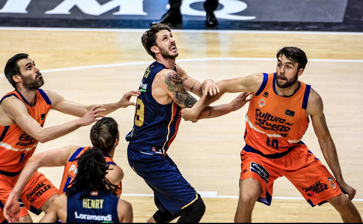 Polonara pelea un rebote ofensivo a Tobey y San Emeterio, del Valencia.