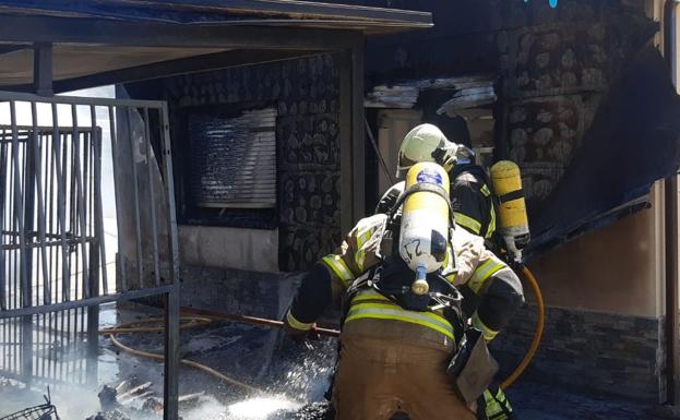 Los bomberos, durante su actuación para sofocar las llamas y los rescoldos. 