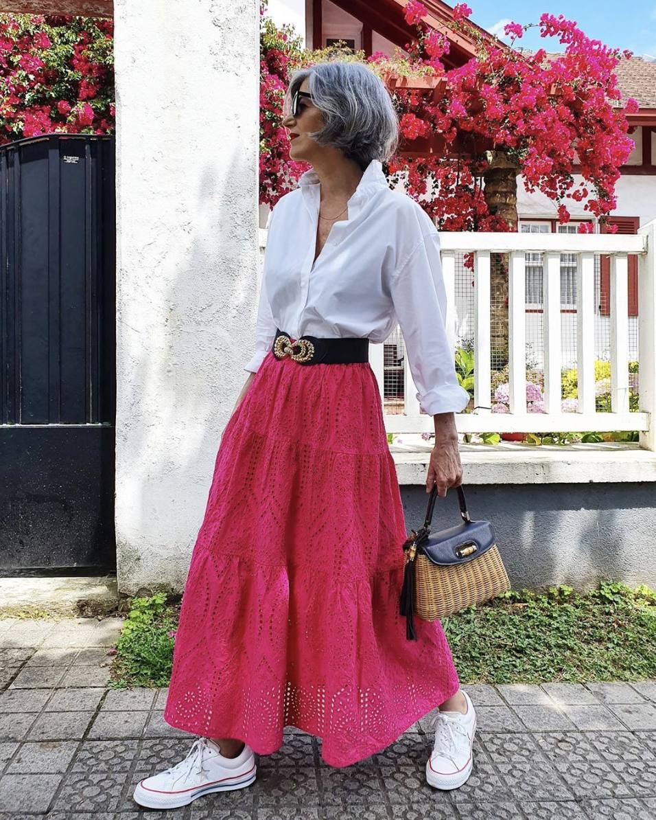 Su pasión por los colores le ha llevado a lucir esta falda frambuesa con calados. La combina con una camisa blanca, un cinturón XL, unas deportivas blancas y un maravillso bolso de mimbre.