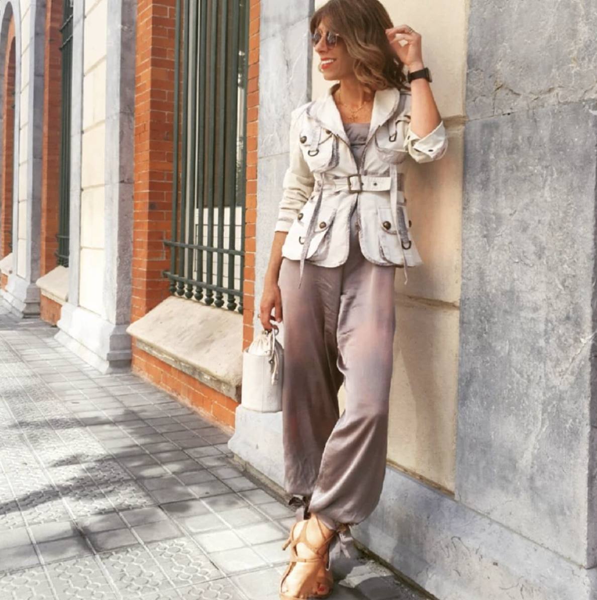 Ya en la villa, opta por un elegante look en tonos sobrios, con un mono de satén, una chaqueta en color crudo y unas sandalias de tacón marrones.