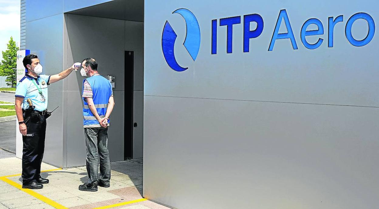Un vigilante toma la temperatura a un empleado de ITP a la entrada de una de sus factorías vizcaínas. 