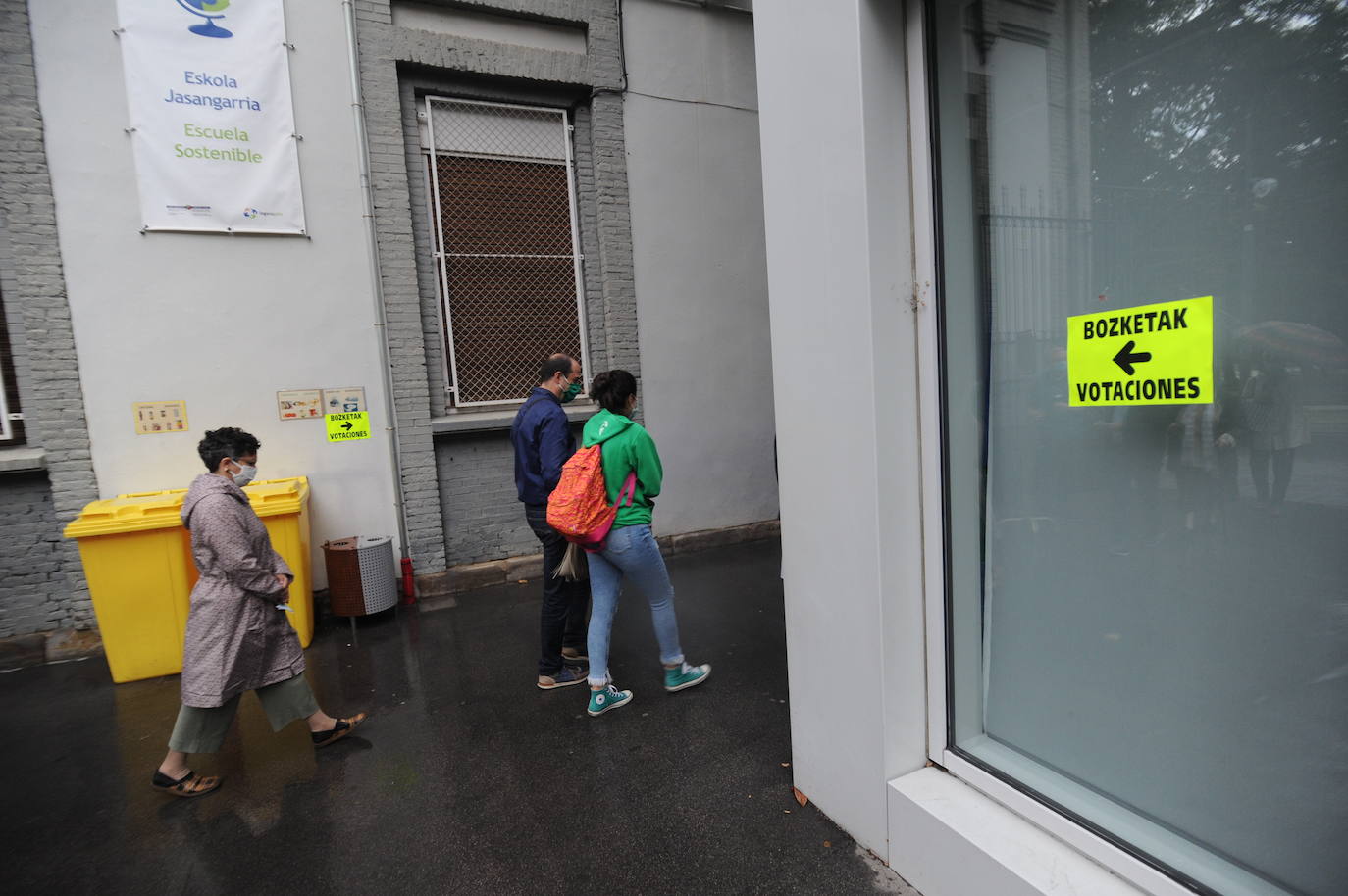 Ciudadanos acuden a votar al colegio Urkide en una mañana gris y lluviosa a primera hora.