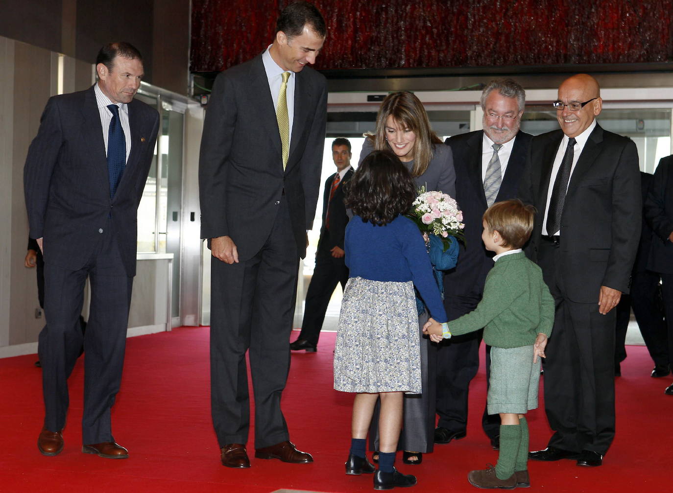 Don Felipe y doña Letizia, acompañados por los entonces ministro de Sanidad, Bernat Soria, lehendakari Juan José Ibarretxe y epresidente de la Caja Vital, Gregorio Rojo, conversan con dos niños a la entrada del edificio de la Vital.