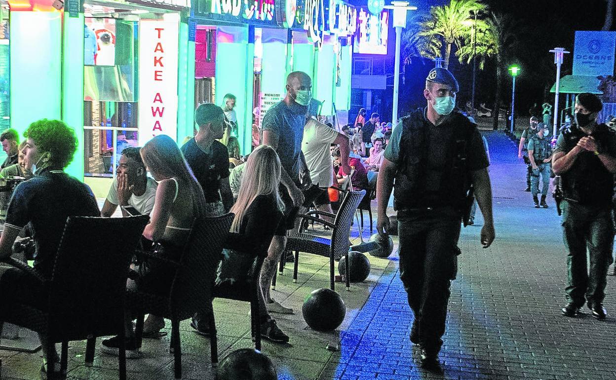 Agentes de la Guardia Civil patrullan una de las calles adyacentes a Punta Ballena, la noche del pasado miércoles.