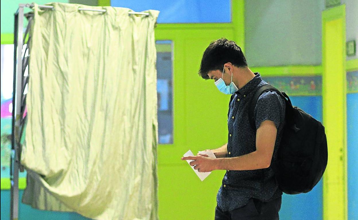 Un joven introduce la papeleta en el sobre durante las autonómicas del pasado domingo.