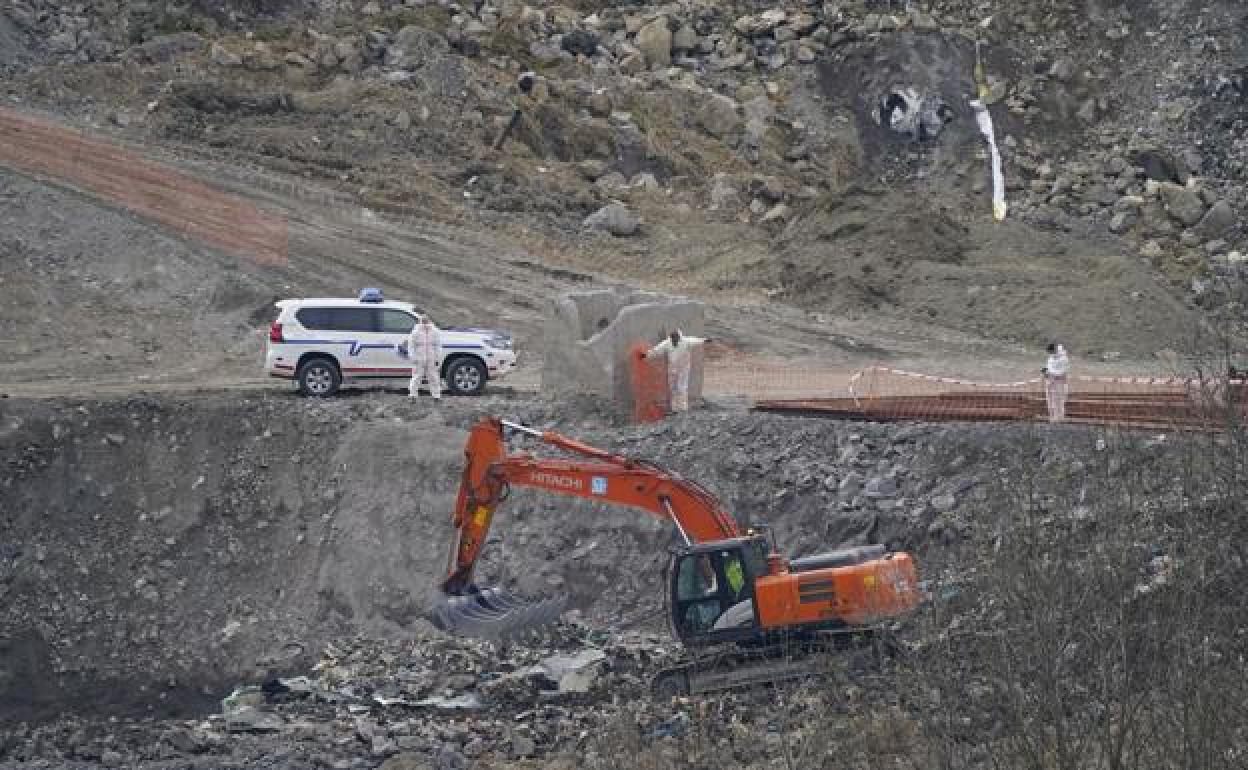 Una excavadora trabaja en el lugar del derrumbe. 