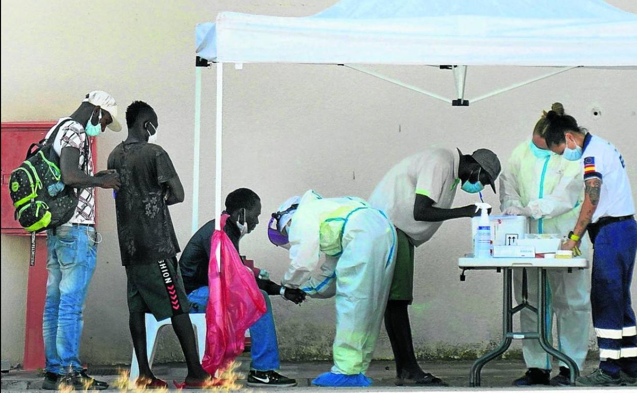 Unos temporeros pasan por un puesto sanitario para hacerse el test en Albacete.