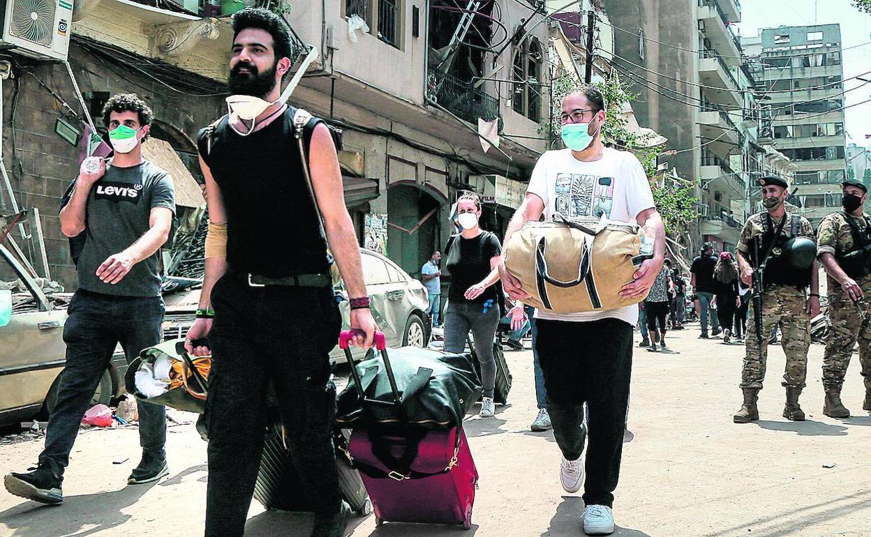 Libaneses abandonan sus casas en el área de Achrafieh, que resultó muy dañada en la explosión. 