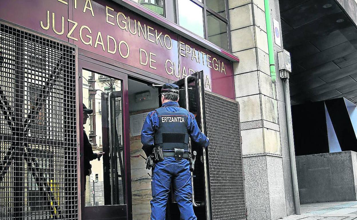 Un ertzaina vigila la entrada al Juzgado de guardia de Bilbao.