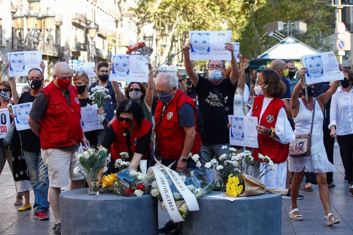 Asistentes dejan rosas blancas y carteles en recuerdo a las 16 personas fallecidas el 17 de agosto de 2017 y a los más de 150 heridos en los atentados de Barcelona y Cambrils durante el homenaje y minuto de silencio celebrado en Las Ramblas con motivo del tercer aniversario del ataque. 