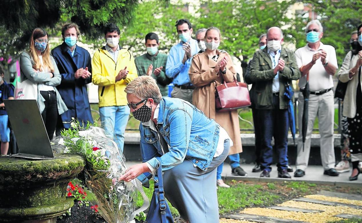La exconcejal Begoña Pereira deposita un ramo de flores en el monolito por las víctimas de Zumarraga.