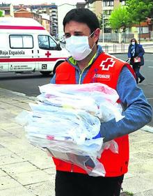 Imagen secundaria 2 - Afluencia.Son muchas las personas que se acercan a la sede interesadas en ser voluntarias. Hombres y mujeres. No existe un perfil determinado del voluntario, aunque en las semanas de aislamiento se experimentó un repunte de jóvenes.Material de protección. Un voluntario de Cruz Roja lleva material de protección durante el confinamiento. 