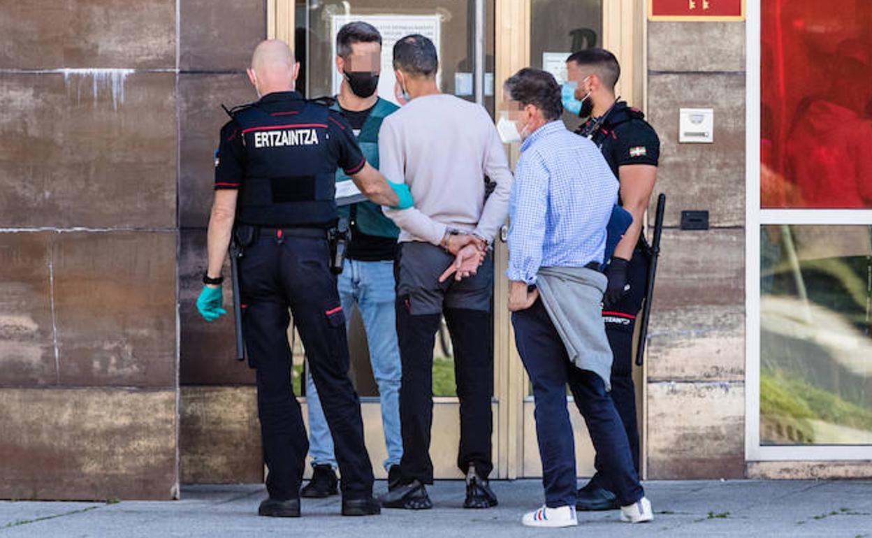 Ertzainas y guardias civiles, con el cabecilla y su abogado de oficio, durante el registro en Salburua. 