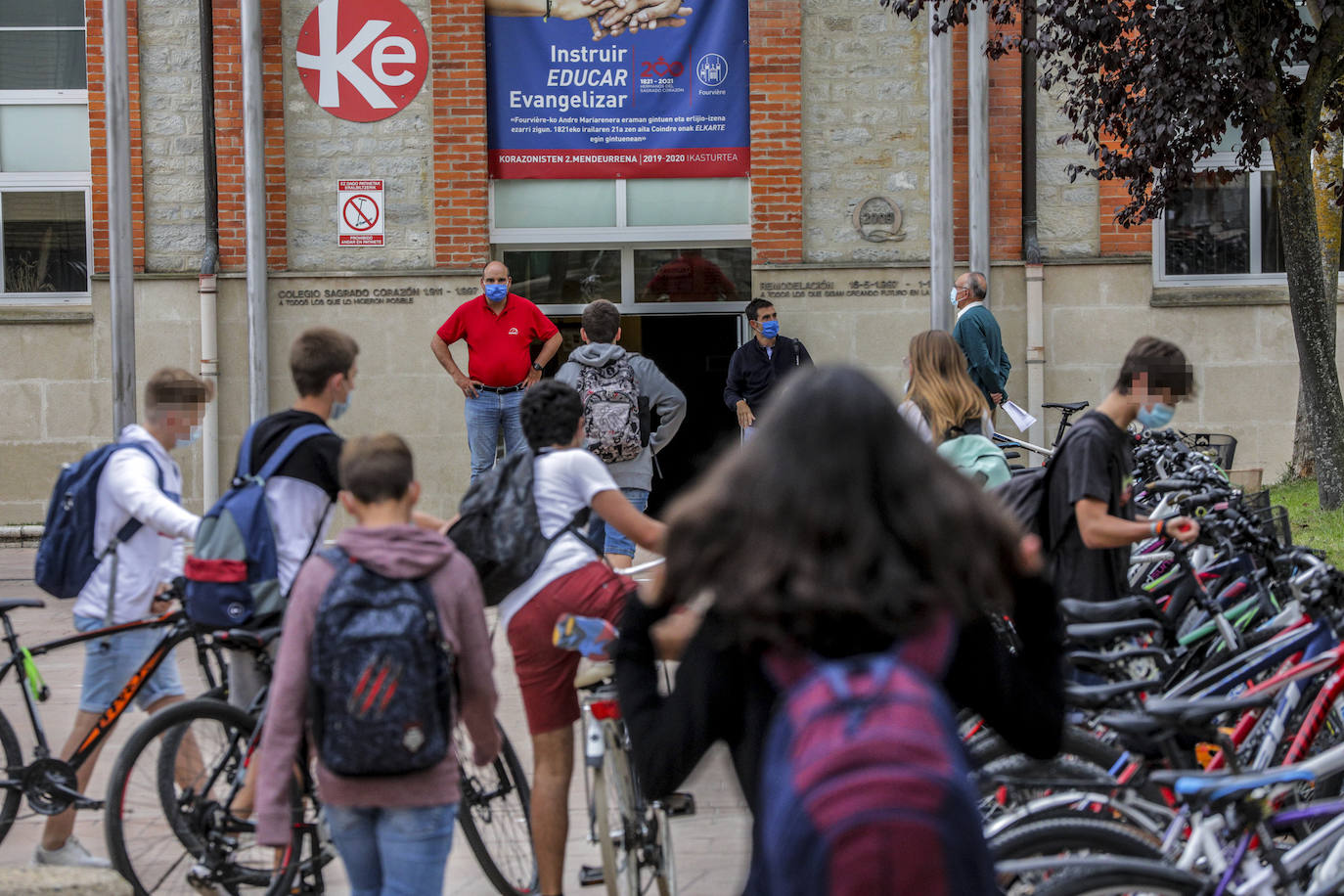 Alumnos de Corazonistas llegan al exterior de su centro educativo. Aguardan las nuevas instrucciones que desde hoy marcarán su día a día en clase.