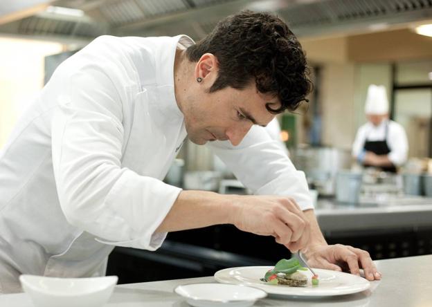 Eneko Atxa da un último toque a un plato.