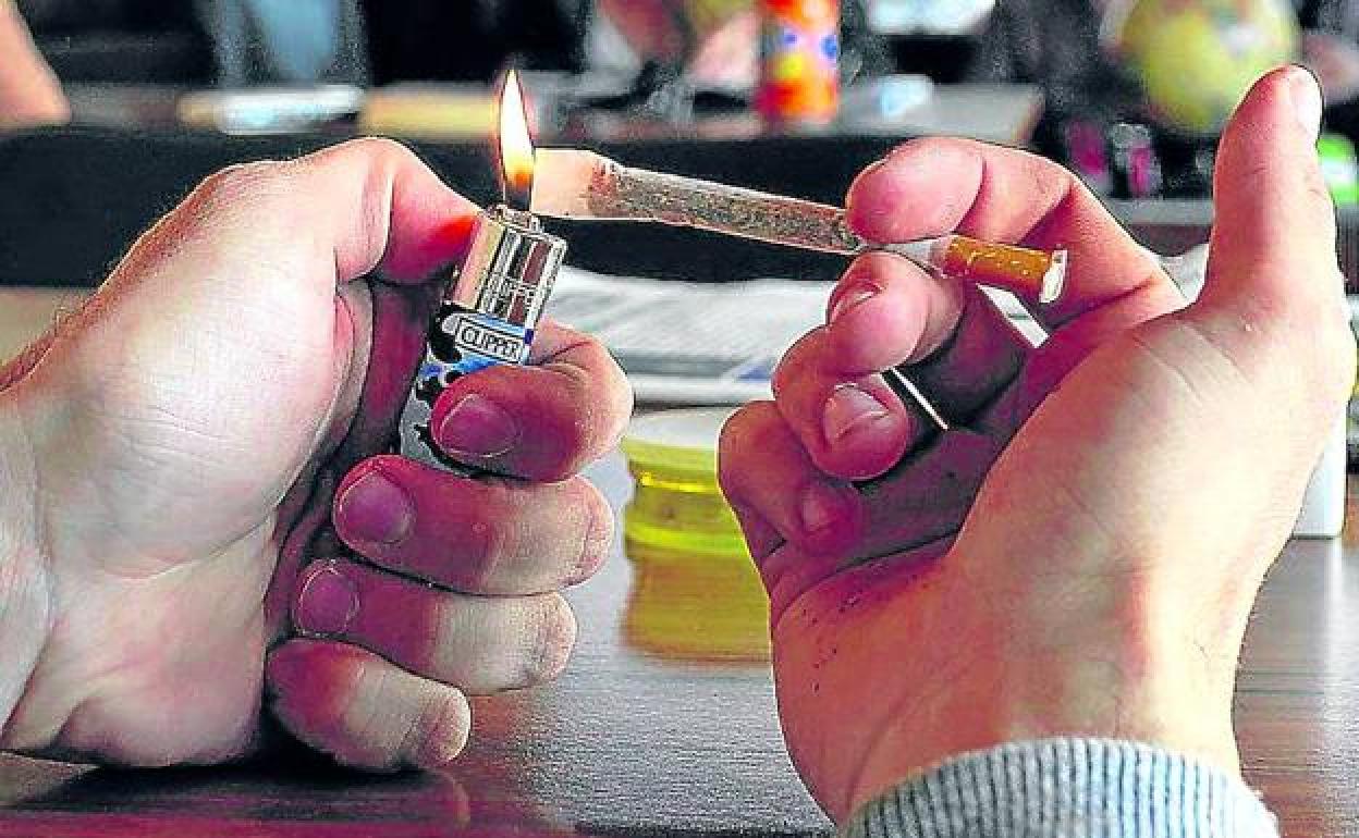 Un joven se enciende un porro en un club de cannabis. 
