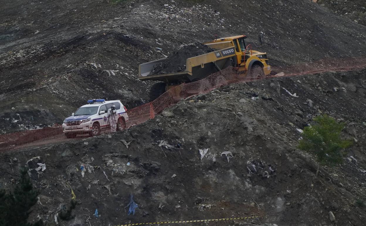 Operarios y ertzainas, en las tareas de búsqueda de los cadáveres en el vertedero. 