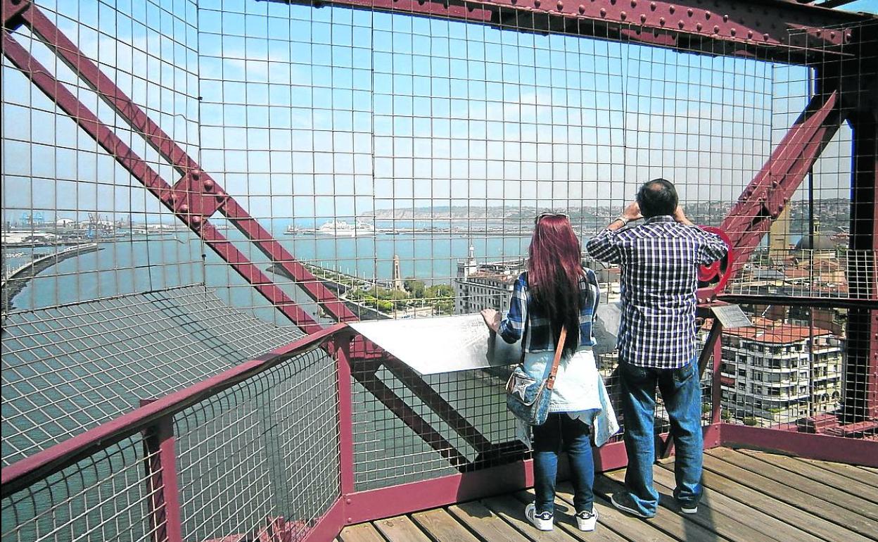 Una pareja observa las espectaculares vistas de El Abra desde la pasarela del Puente Colgante. 