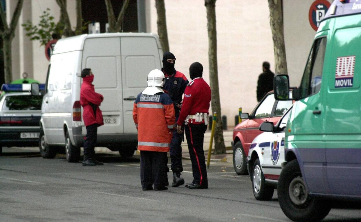 Agentes policiales y bomberos observan el lugar en el que ha sido asesinado Maximo Casado, Jefe de Servicios de la Prision de Nanclares de la Oca a manos de ETA