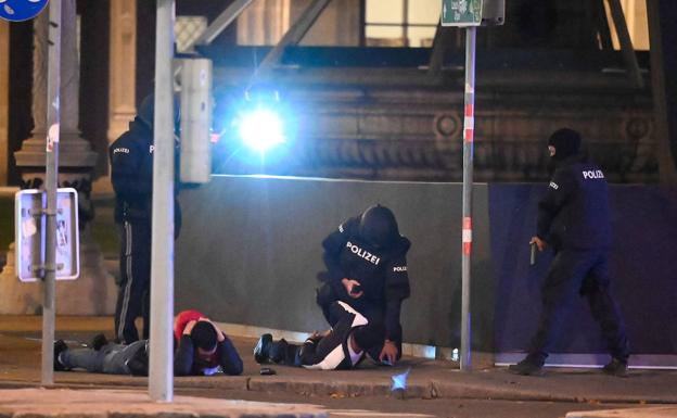 Varios policías apuntan con sus armas a dos sospechosos tras el tiroteo perpetrado anoche en Viena cerca de una sinagoga.